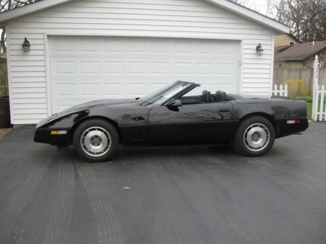 black corvette convertible with black top and gunmetal leather seats