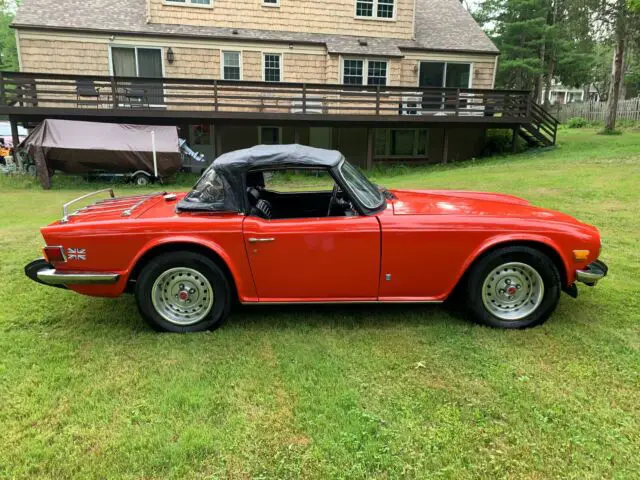 red convertible triumph tr6 with 2.5l inline 6 cylinder engine